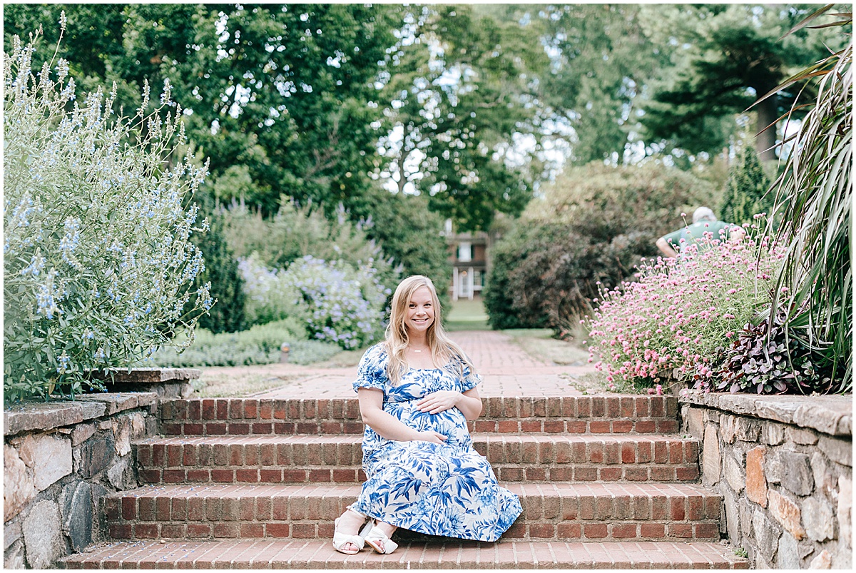 Longwood gardens maternity portraits with Katie for her baby boy. Katie is seen wearing a blue maternity dress surrounded by the greenery of the botanical gardens