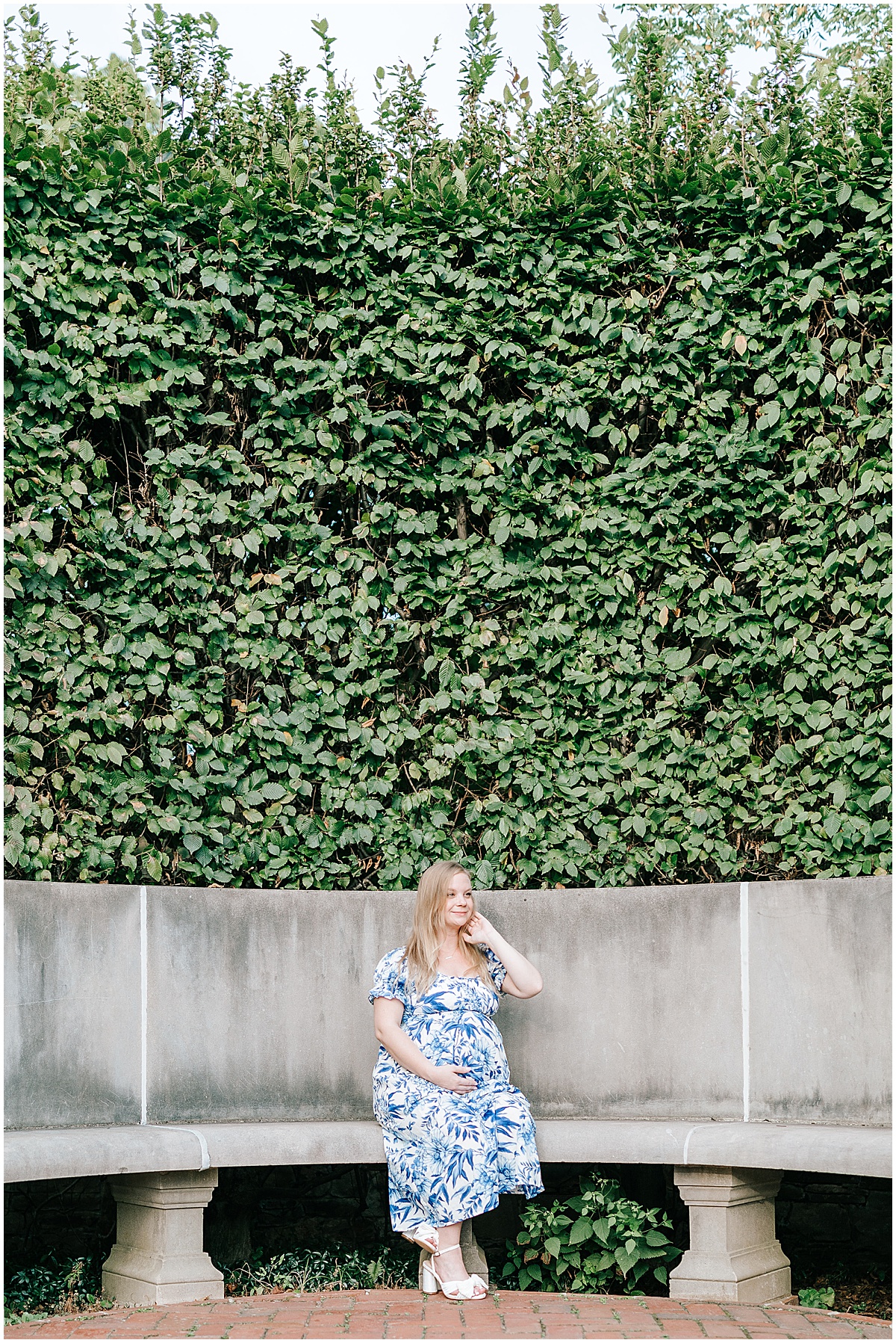 Longwood gardens maternity portraits with Katie for her baby boy. Katie is seen wearing a blue maternity dress surrounded by the greenery of the botanical gardens